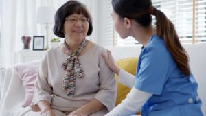 A senior talking with a family member while unpacking personal items in a cozy, well-lit assisted living room.